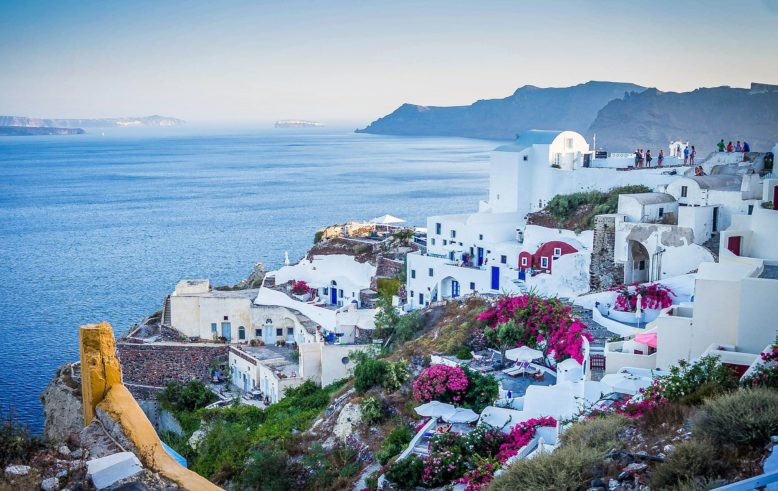 La isla de Santorini en el Mar Egeo, las casas blancas con flores en los acantilados atraen a los turistas