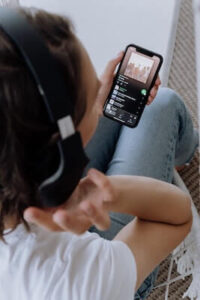 Persona que escucha la lista de reproducci&oacute;n en el tel&eacute;fono