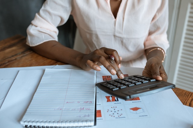 La investigación muestra que las mujeres tienen lo que se necesita para ser grandes CEO Mujer, utilizar, calculadora, en el escritorio