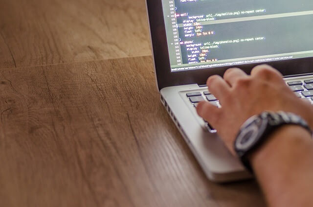 Persona que trabaja en la computadora port&aacute;til con c&oacute;digo a la vista