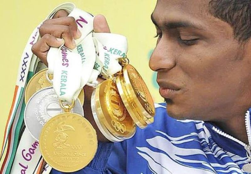 Sajan Prakash admirando sus medallas de oro