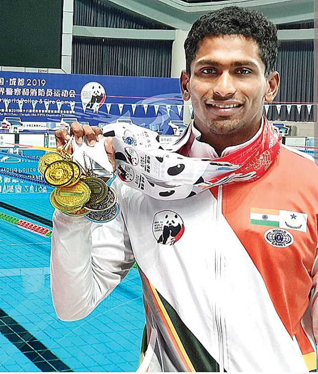 Sajan Prakash mostrando sus medallas de oro