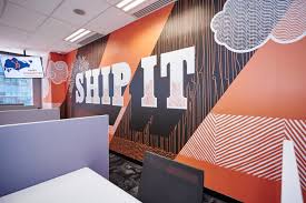 Mural naranja que dice 'env&iacute;alo' en una pared en la oficina de HubSpot en Singapur