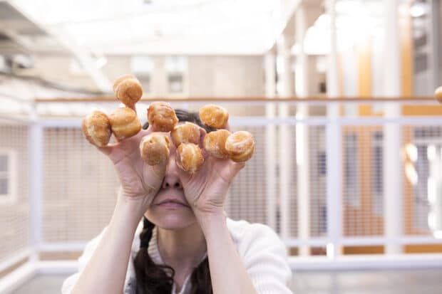 persona sosteniendo mini donas en cada dedo