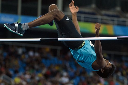 Mariyappan Thangavelu capturado en el aire durante un evento de salto de altura