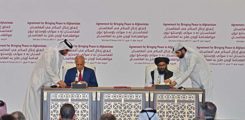 El representante estadounidense Zalmay Khalilzad (izquierda) y Baradar (derecha) firman el Acuerdo para llevar la paz a Afganist&aacute;n en Doha, Qatar, el 29 de febrero de 2020