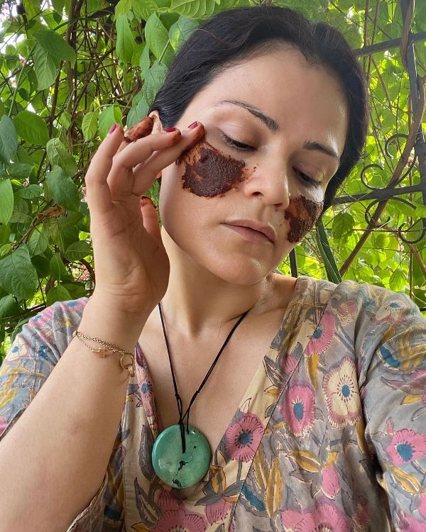 Vasudha Rai mientras se aplica un producto de belleza en la cara.