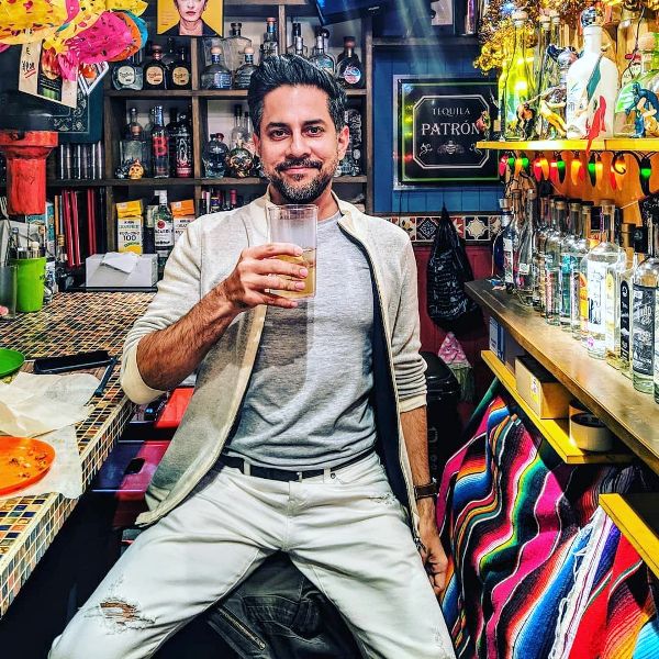 Vishen Lakhiani sosteniendo un vaso de alcohol