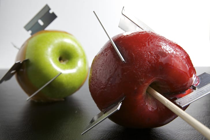 Navajas incrustadas en dos manzanas de caramelo