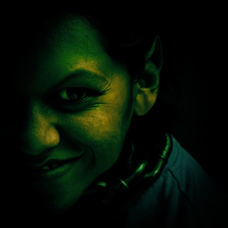 Una mujer sonriente parecida a un troll pintada de verde oscuro