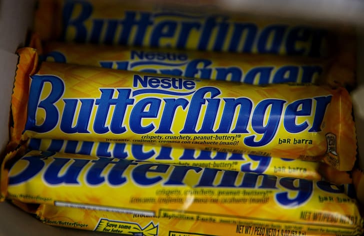Un mont&oacute;n de barras de caramelo Butterfinger en una caja.