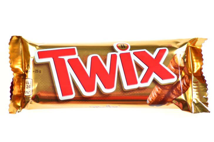Una barra Twix sobre un fondo blanco.