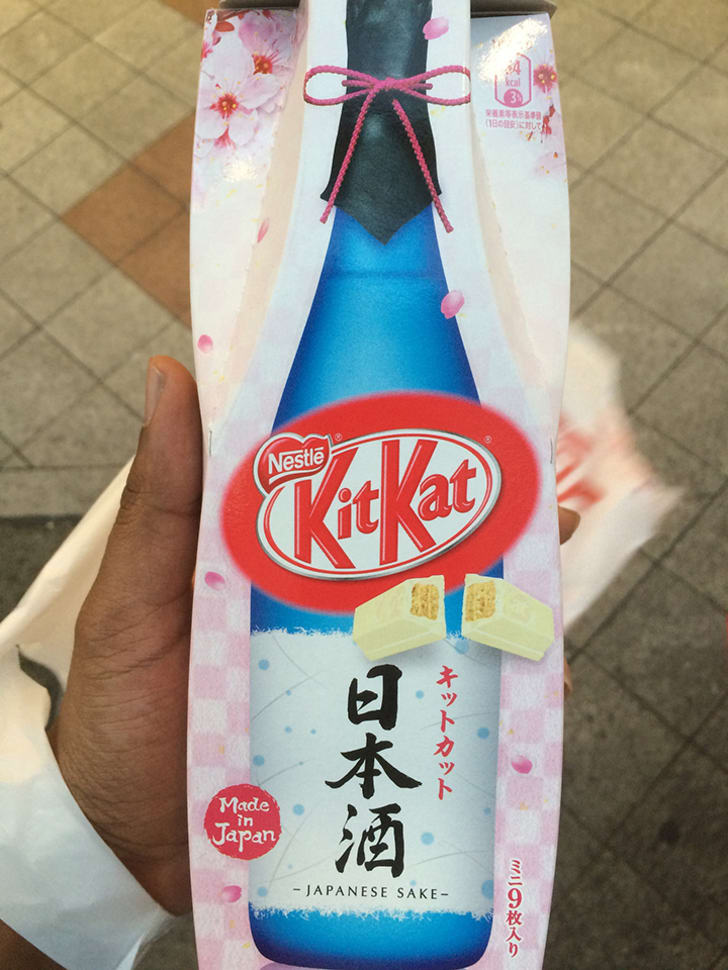 Una persona que sostiene un paquete de kit kats con sabor a sake.