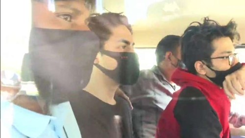 Aryan Khan y Arbaaz Merchant (sudadera con capucha roja) con funcionarios de la NCB después de su arresto