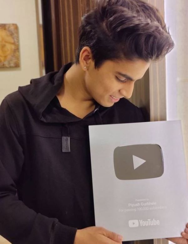 Piyush Gurbhele sosteniendo su bot&oacute;n plateado de reproducci&oacute;n de YouTube