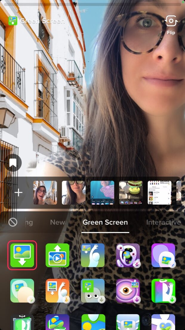 Pantalla verde de persona con edificios en segundo plano.